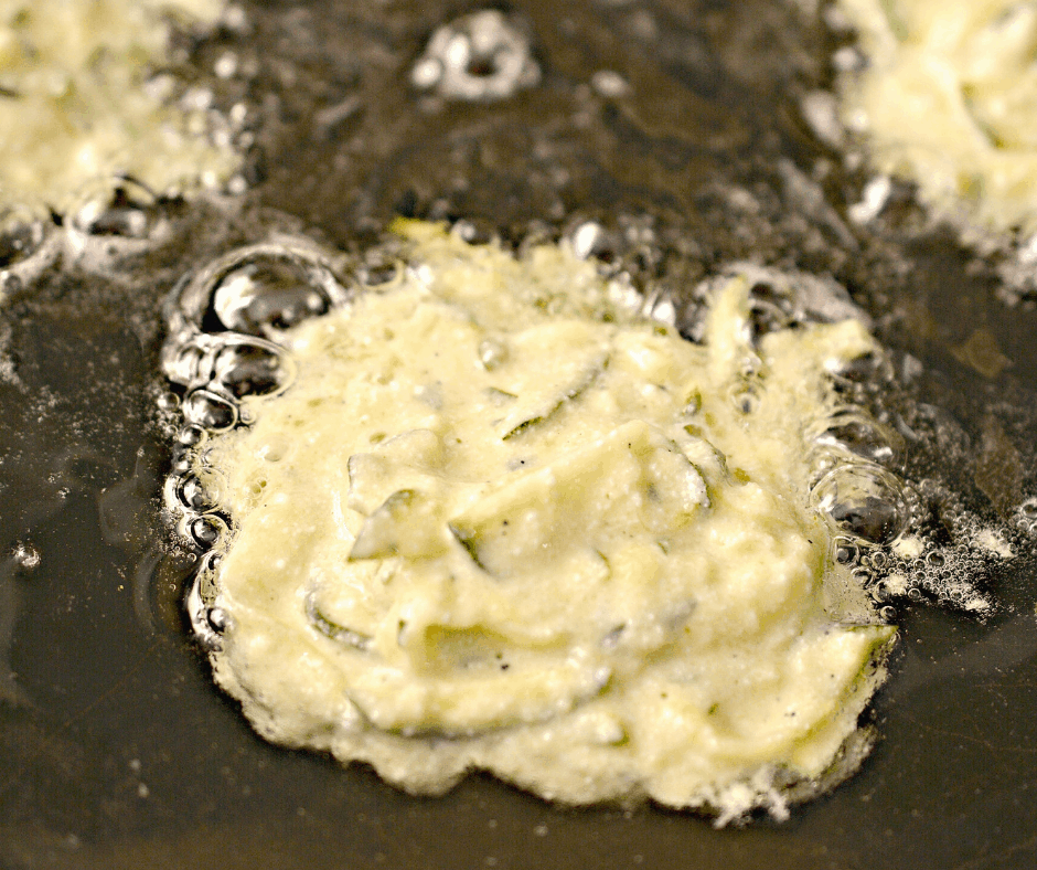 fritter batter being added to the skillet 