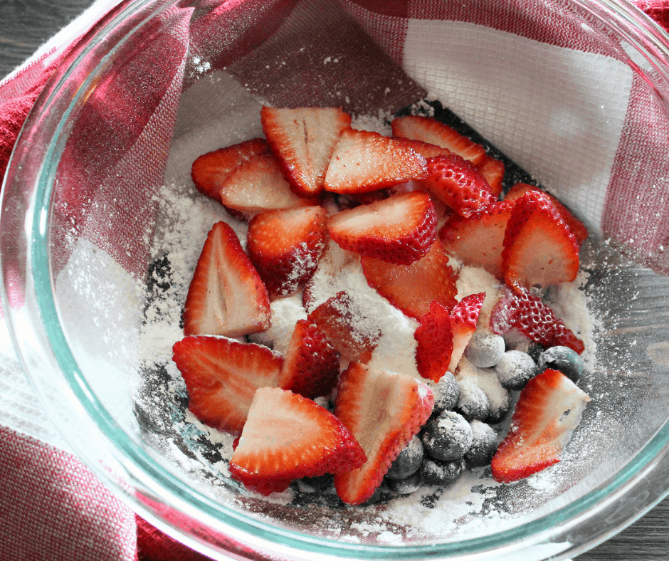 adding the berries into the glass bowl 