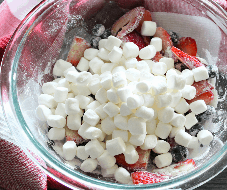 adding the mini marshmallows to the glass bowl 