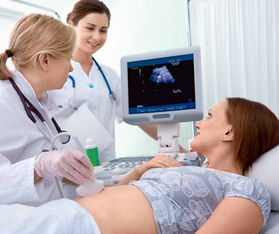 mom with doctors receiving an ultrasound to determine due date