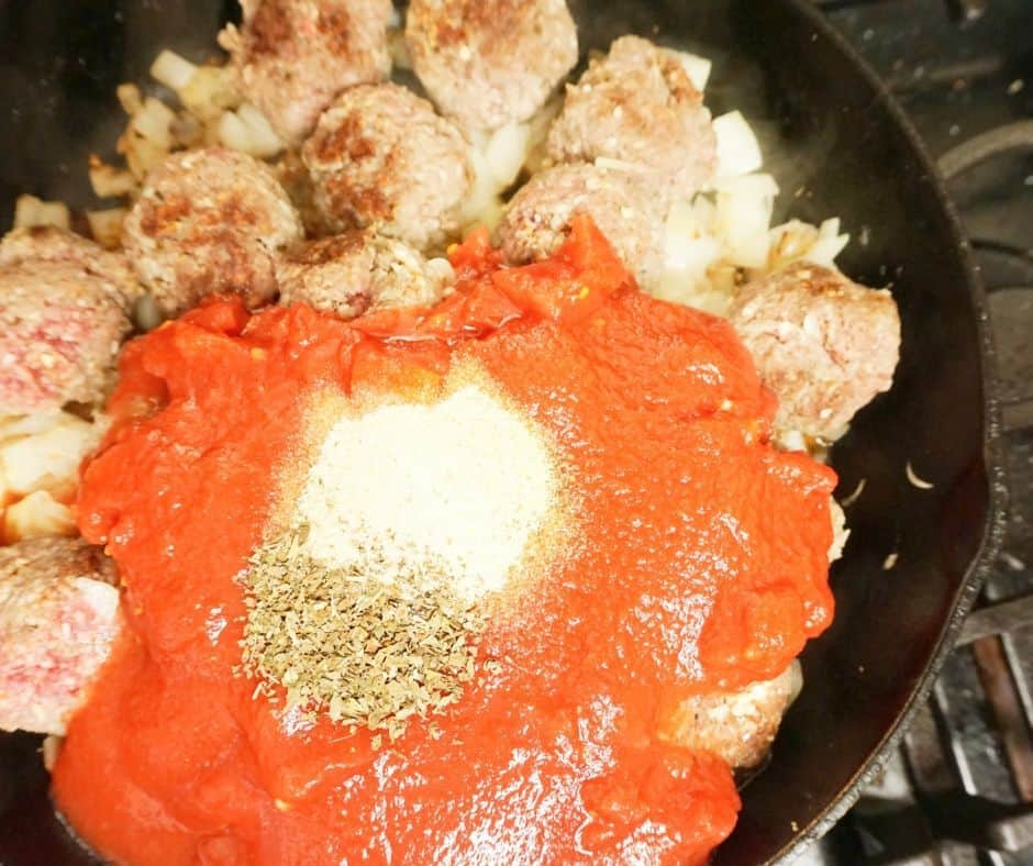 meatballs and sauce cooking in a skillet