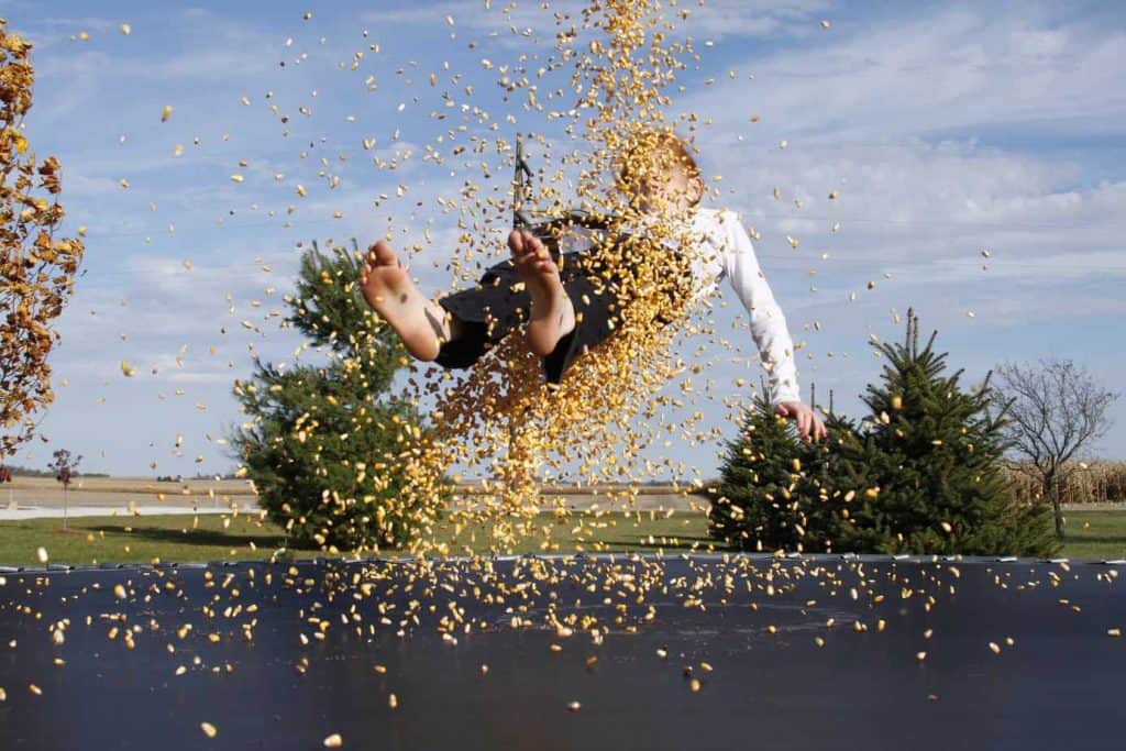 child playing outside on trampoline 