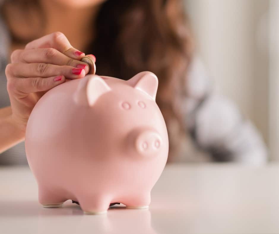 frugal woman putting money into piggy bank to save money