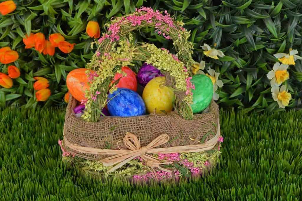 Easter Basket on grass in garden filled with colored eggs and no candy