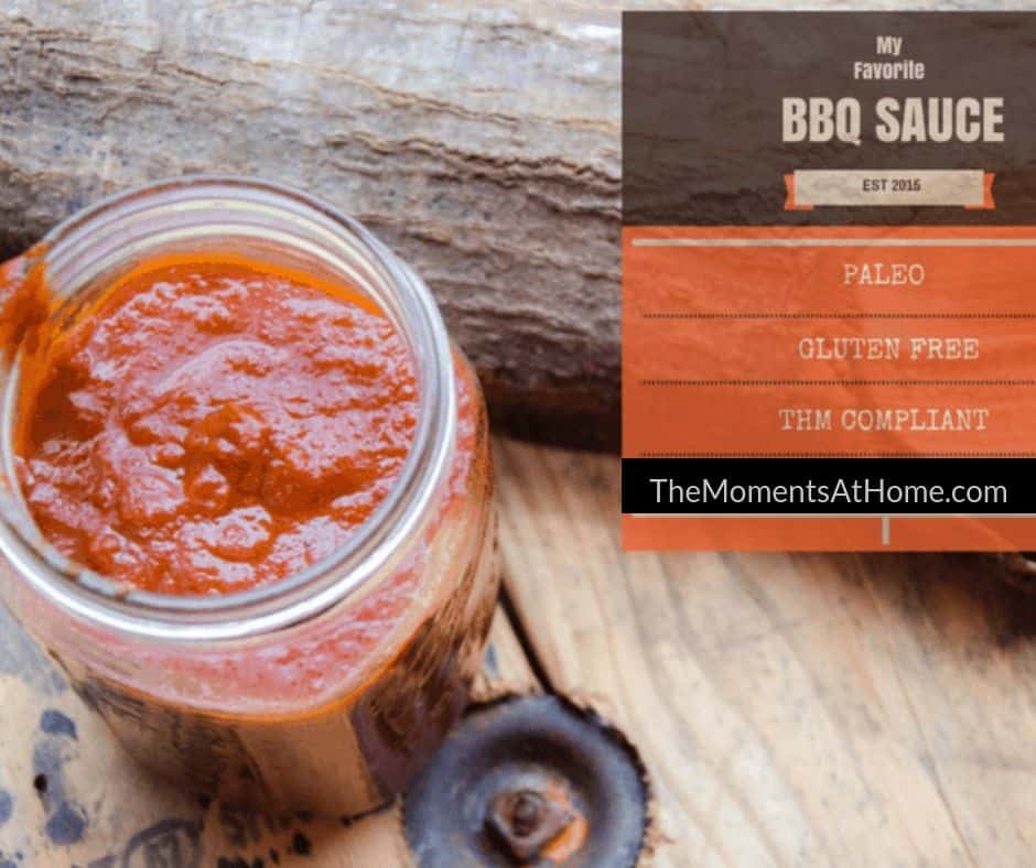 healthy homemade BBQ sauce that is sugar free in a jar near a log on a wooden table