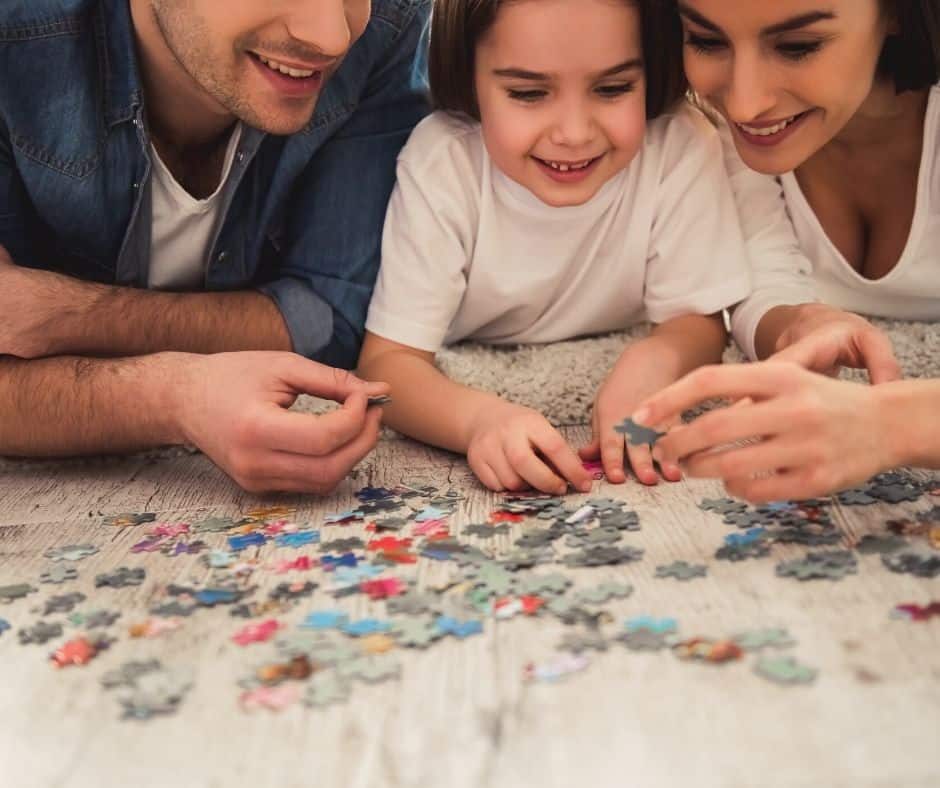 puzzles over vacation family tradition idea with three people working puzzle