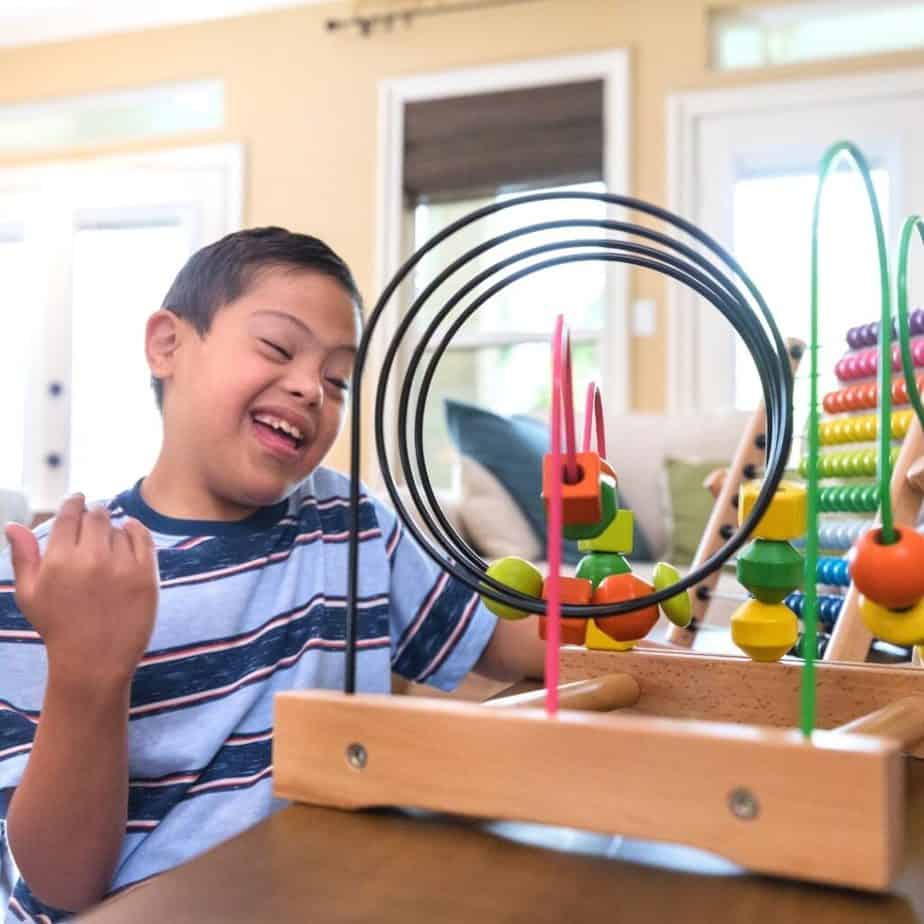boy with special needs playing with fine motor developing toy