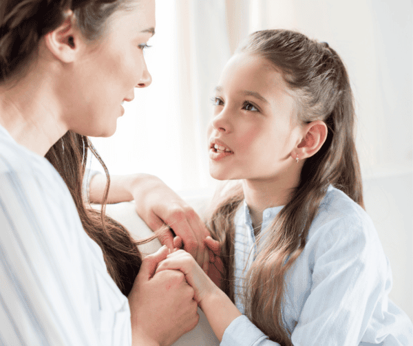 mom looking at daughter, holding hands, serious calm talk